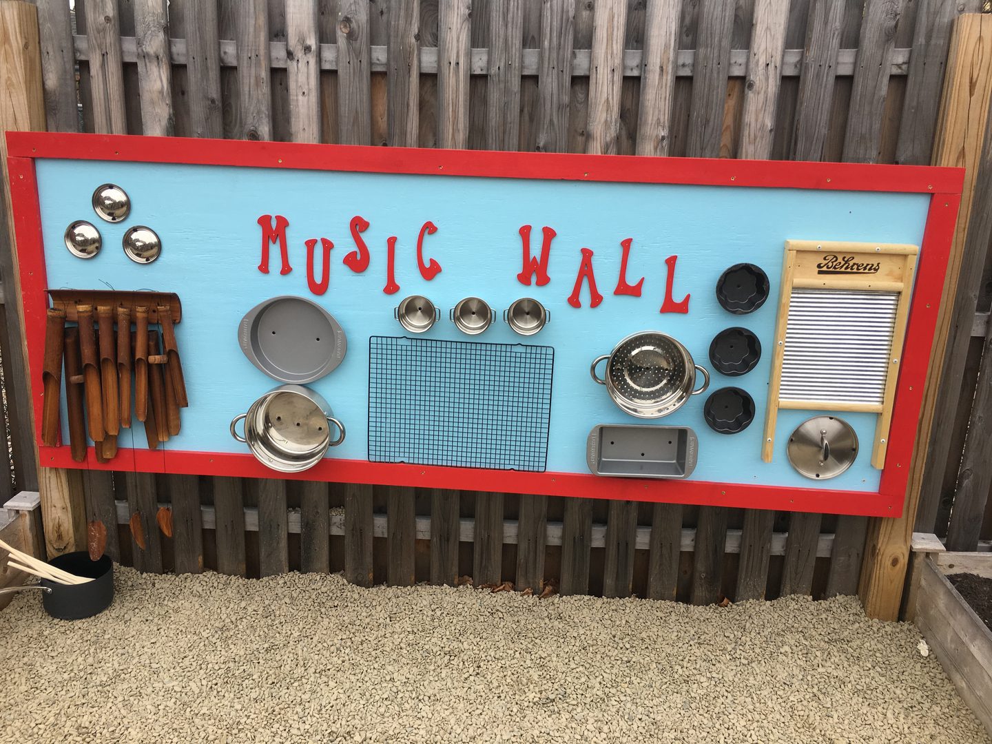 Outdoor music wall with kitchen utensils.